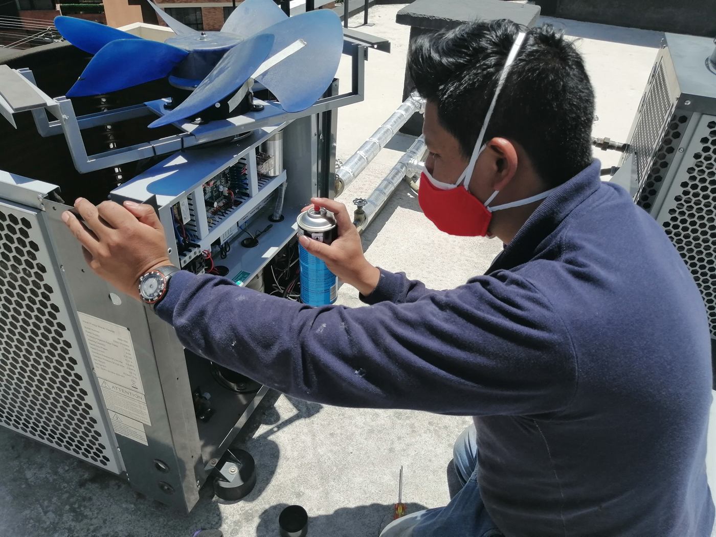 Técnico de ISIYER revisando el panel eléctrico de una bomba de calor en una azotea