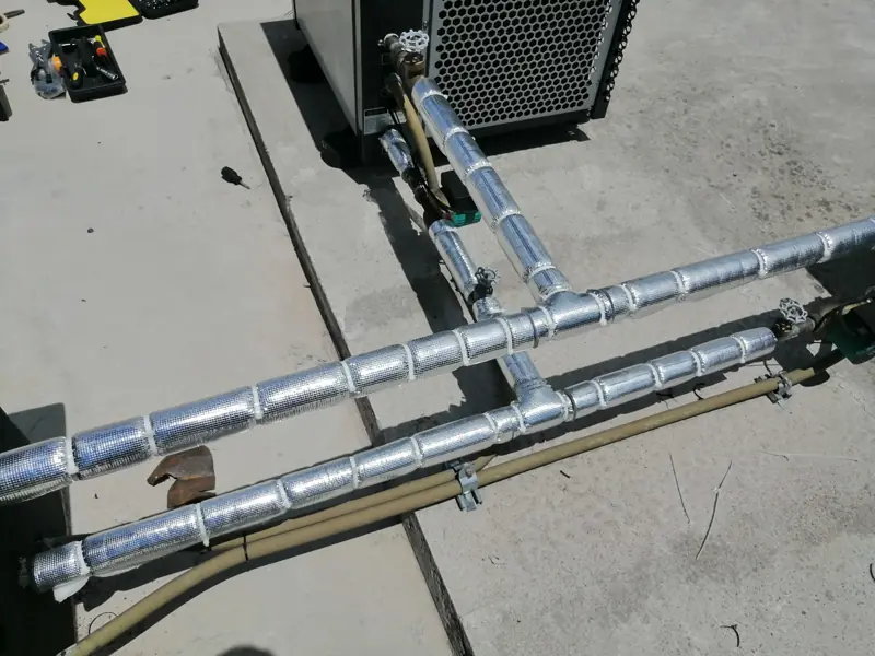 Tuberías con aislamiento térmico conectadas a una bomba de calor en una terraza