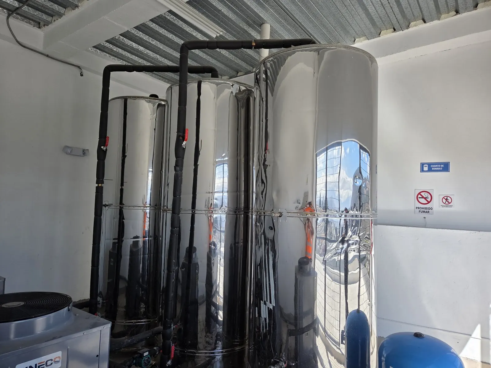 Tanques acumuladores de agua caliente de acero inoxidable en la terraza de un edificio