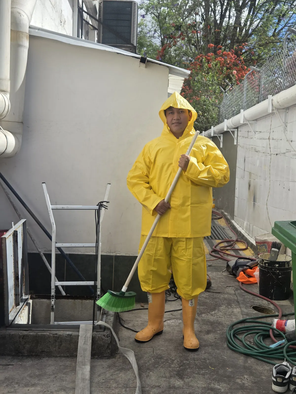 Técnico de ISIYER con traje impermeable limpiando el interior de una cisterna en Quito