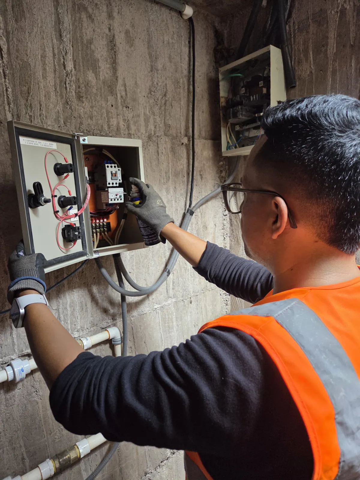 Técnico revisando tablero de control de bombas de agua en Quito