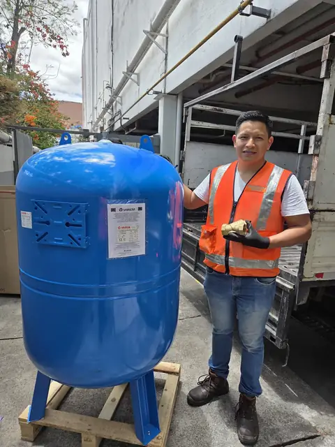 Técnico de ISIYER con tanque hidroneumático nuevo listo para instalar en Quito