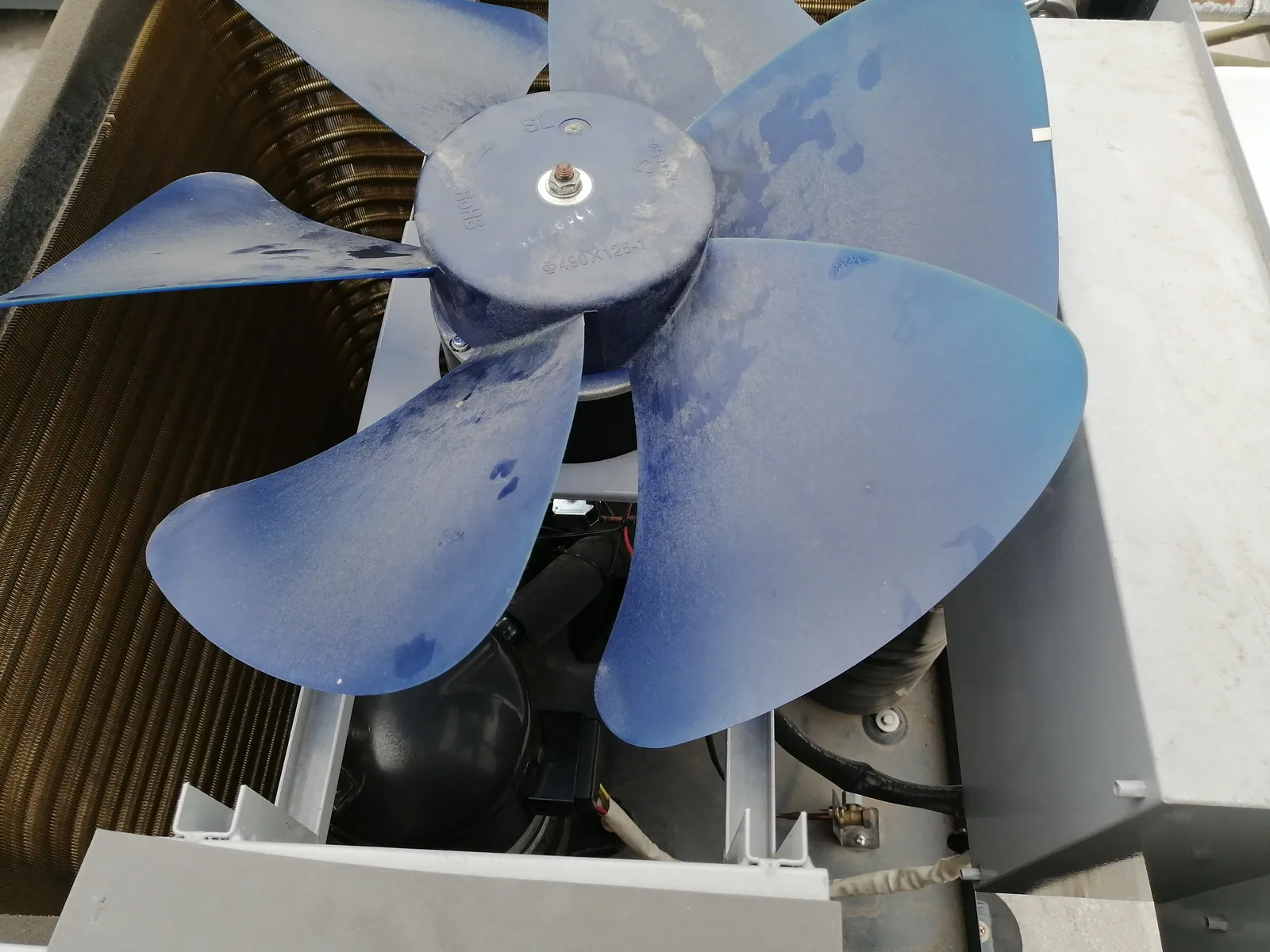 Detalle del ventilador y serpentín de una unidad exterior de aire acondicionado